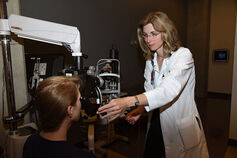 An ophthalmologist works with a patient.